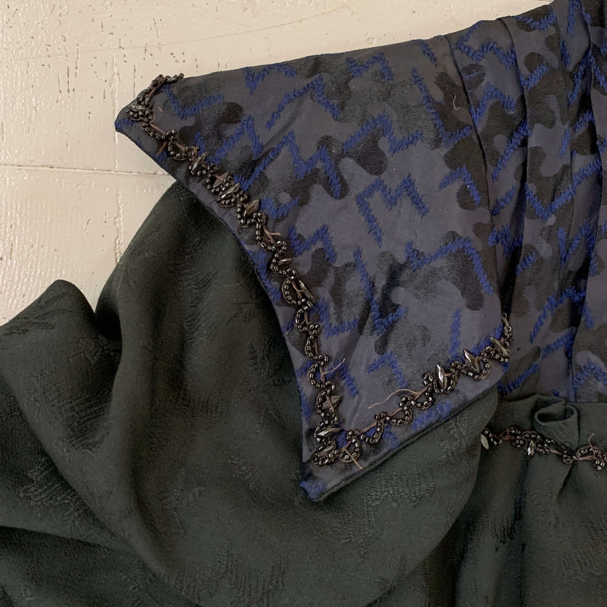 detail view of black glass beading and navy blue silk