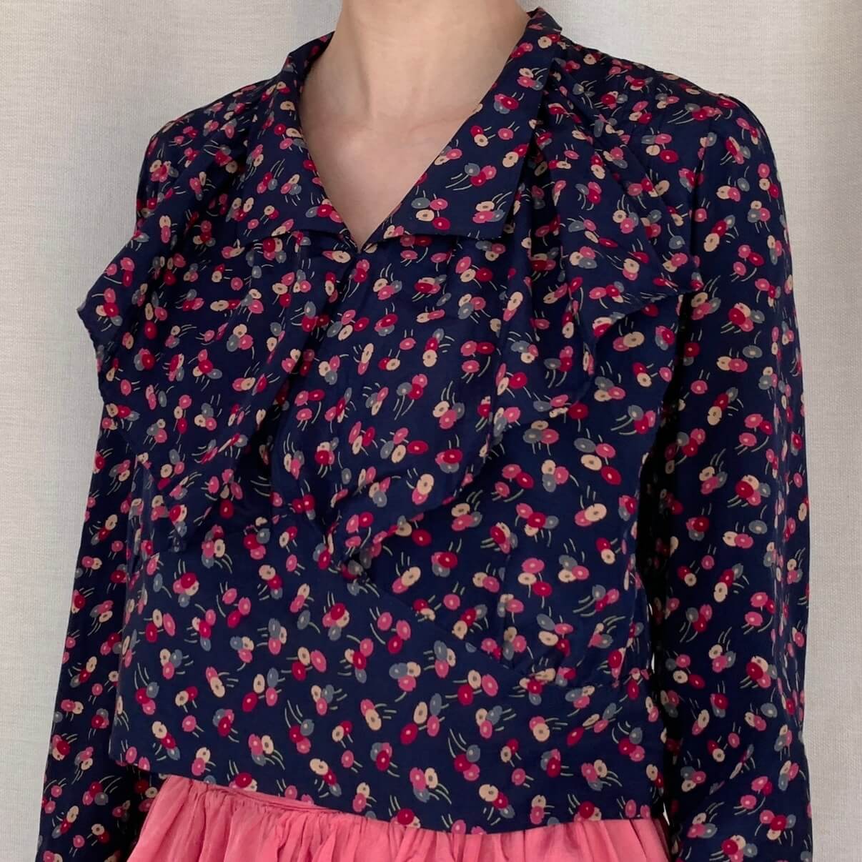 model wearing the navy top with ruffle collar and pink lollipop flowers