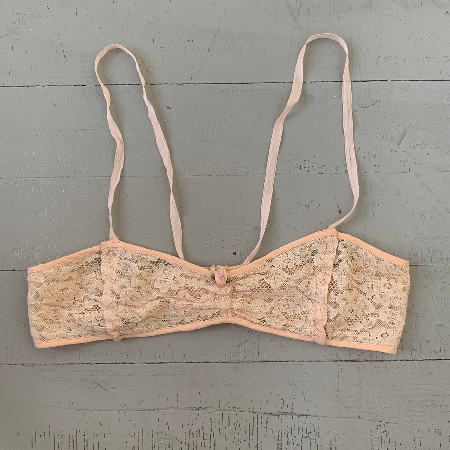 1920's bra made of beige lace and pink trim with rosette