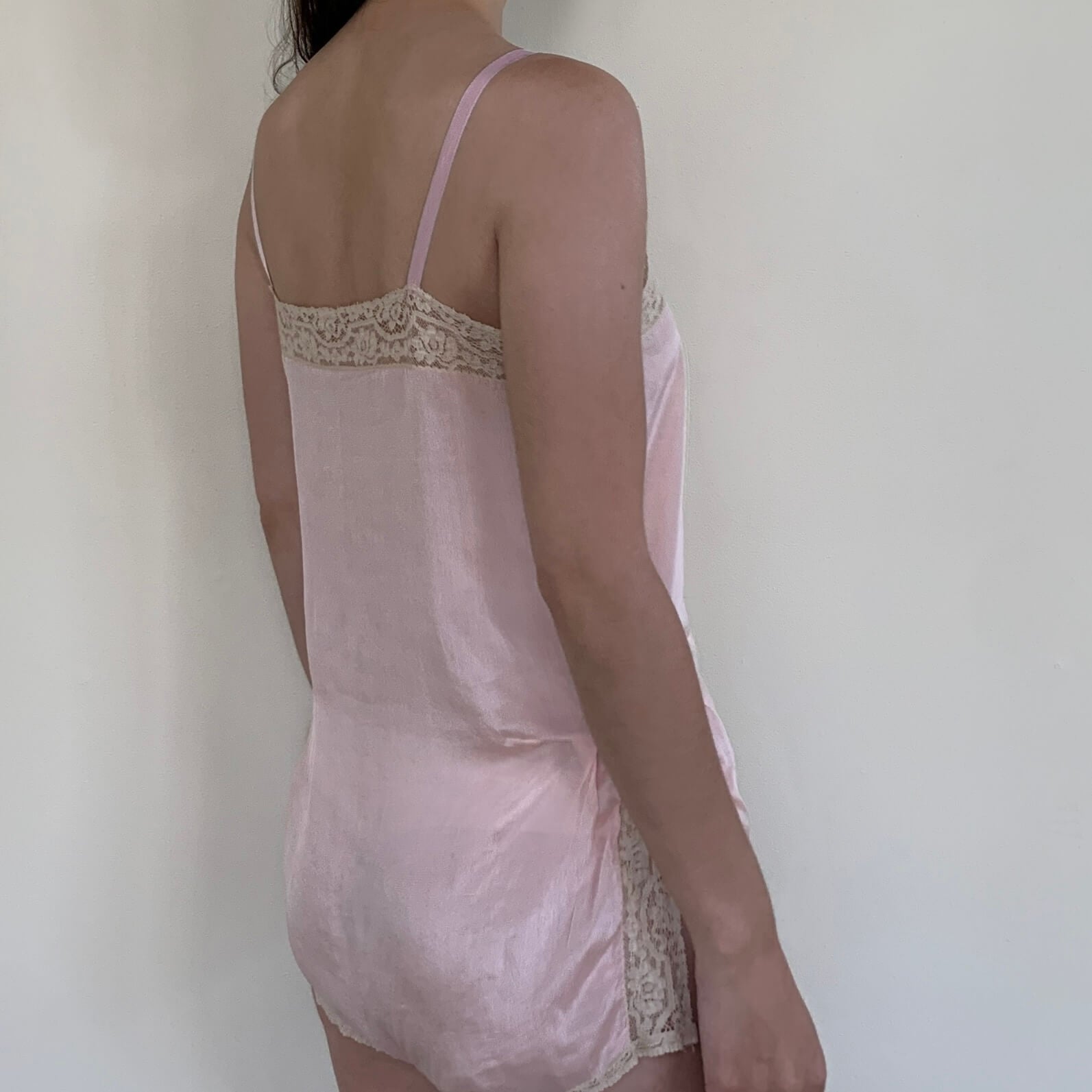 model wearing a vintage pink teddy turned to the side