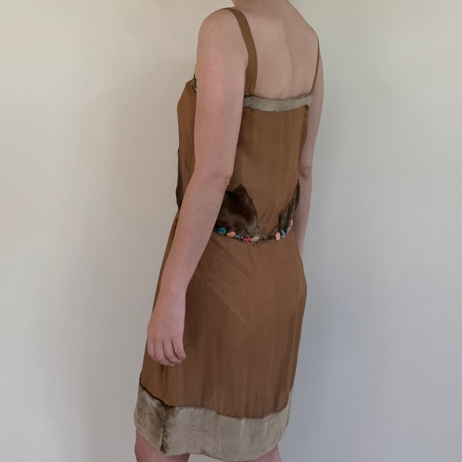 model wearing a brown dress turned to the side
