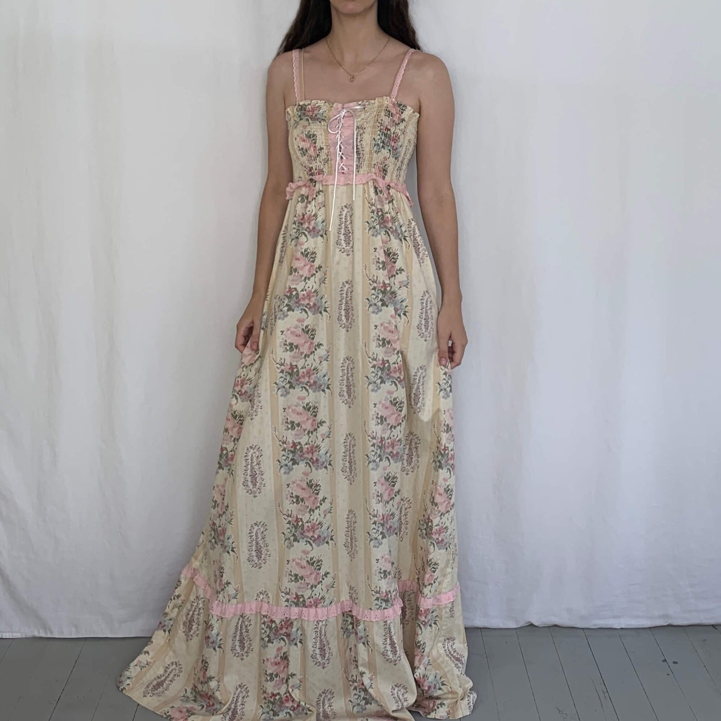 floral 70s maxi dress on a model in front of a white background