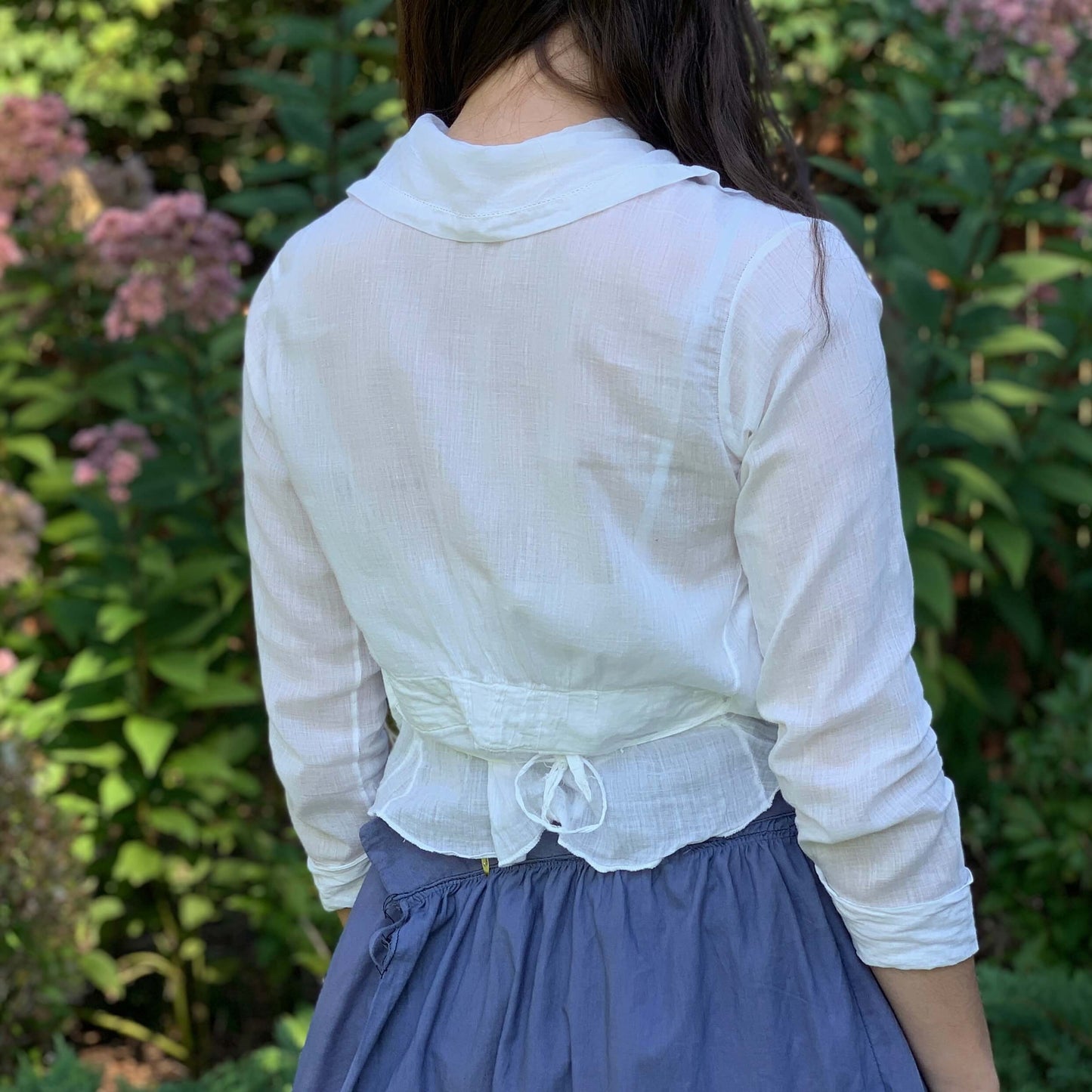 back of white cotton shirt from the 1900s on a woman standing outside