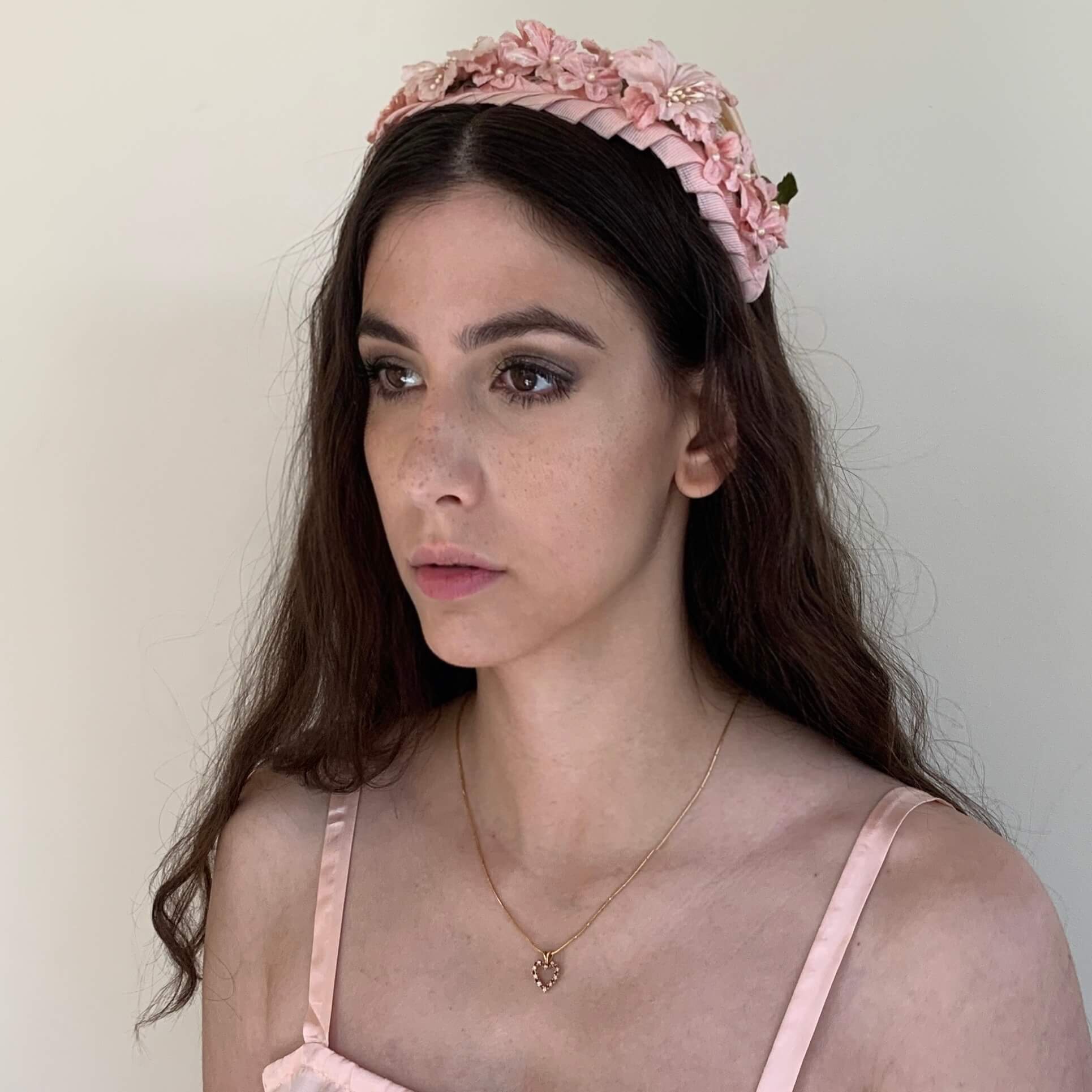 model wearing 1950s pink casque hat with small velvet flowers