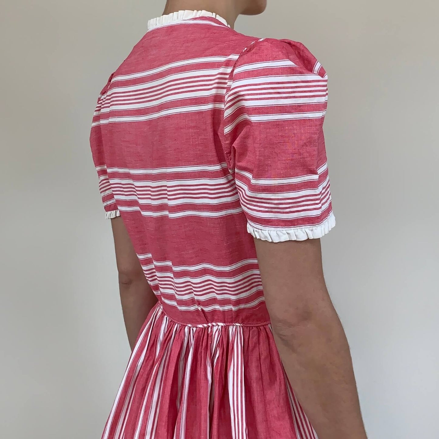 view showing the puff sleeves on the pink and white striped dress