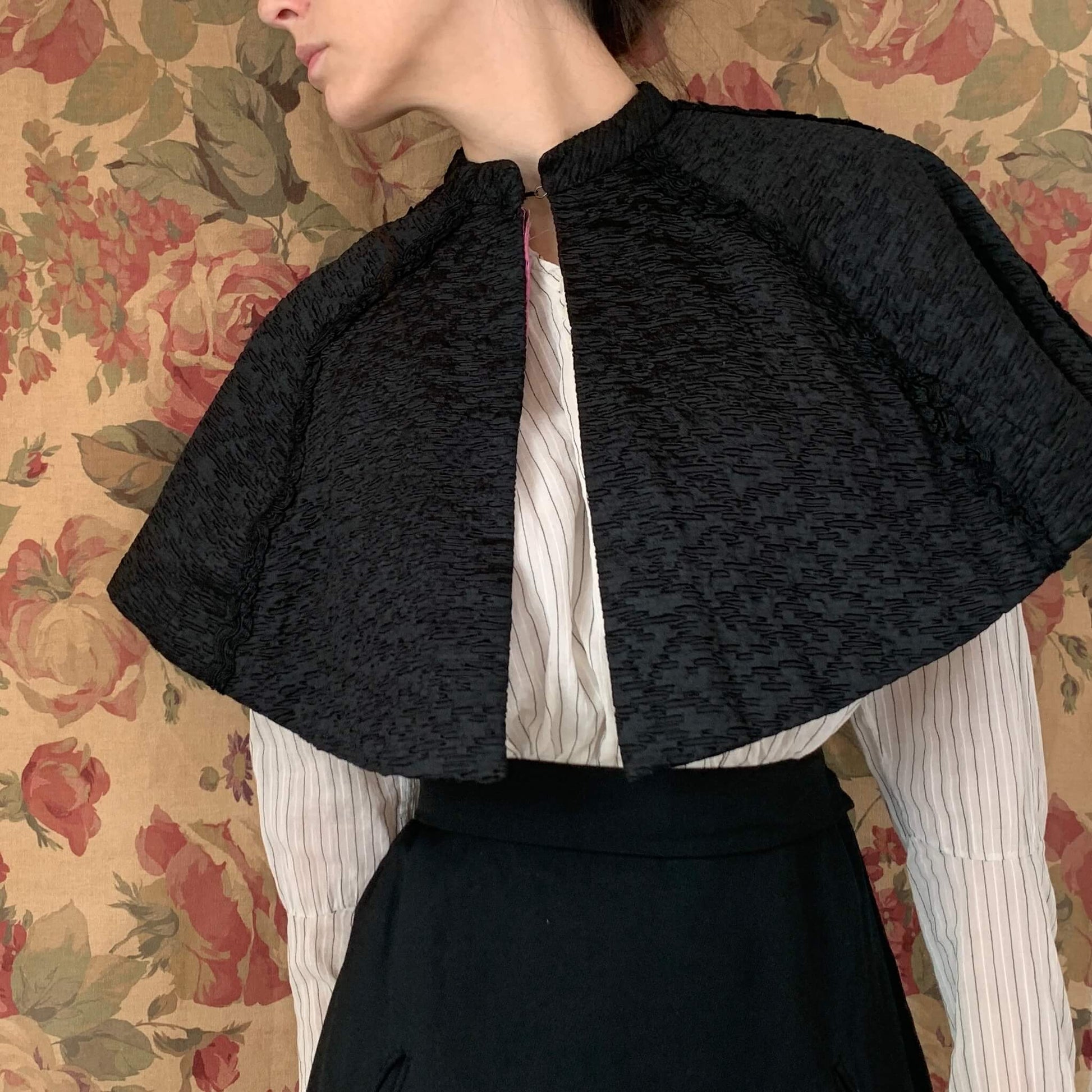 The antique capelet with textured black fabric shown on the model