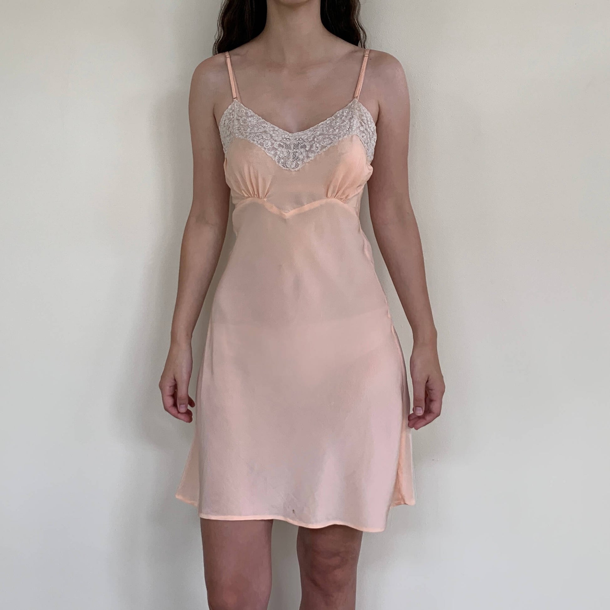 model wearing a pink vintage silk slip dress with ivory lace trim
