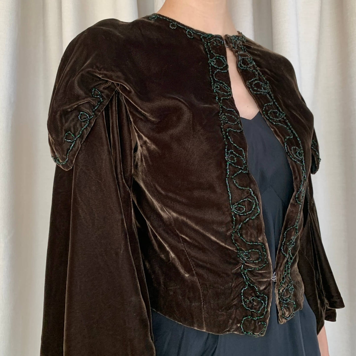 detail of the black and green glass beads on the velvet coat