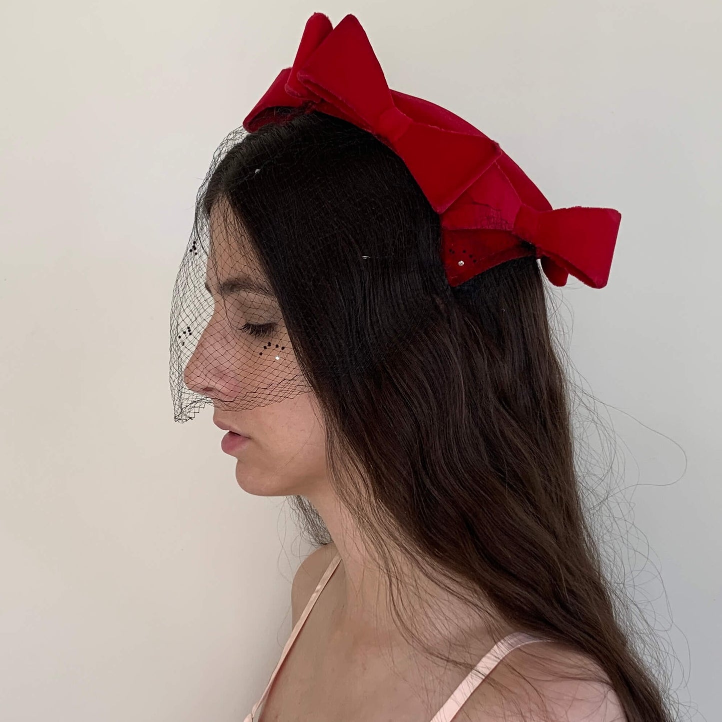 side view of vintage red hat with black veil and bows
